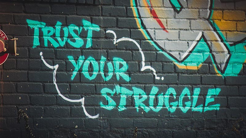Graffiti that says Trust Your Struggle