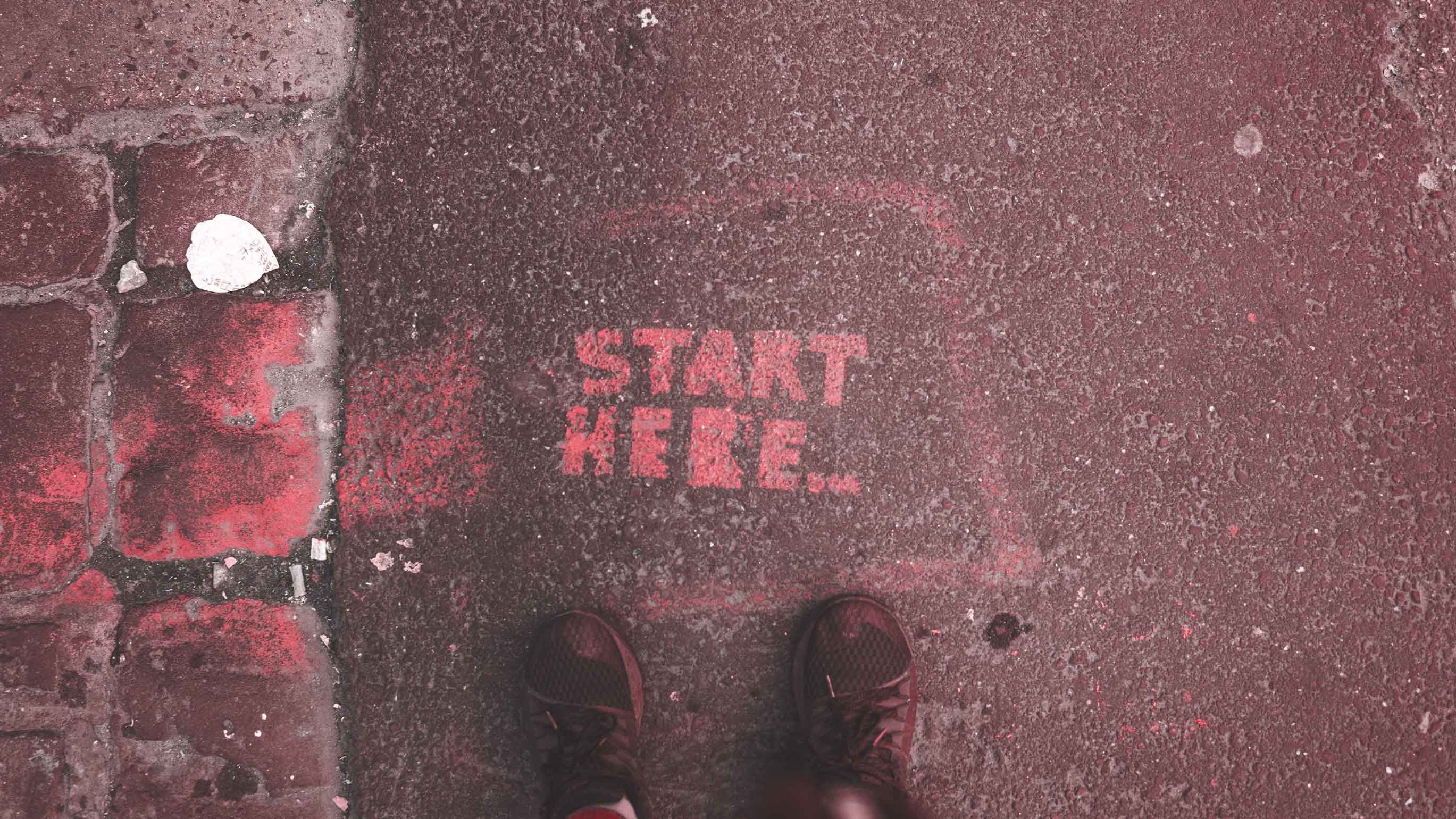 Paint on street that says "Start Here"