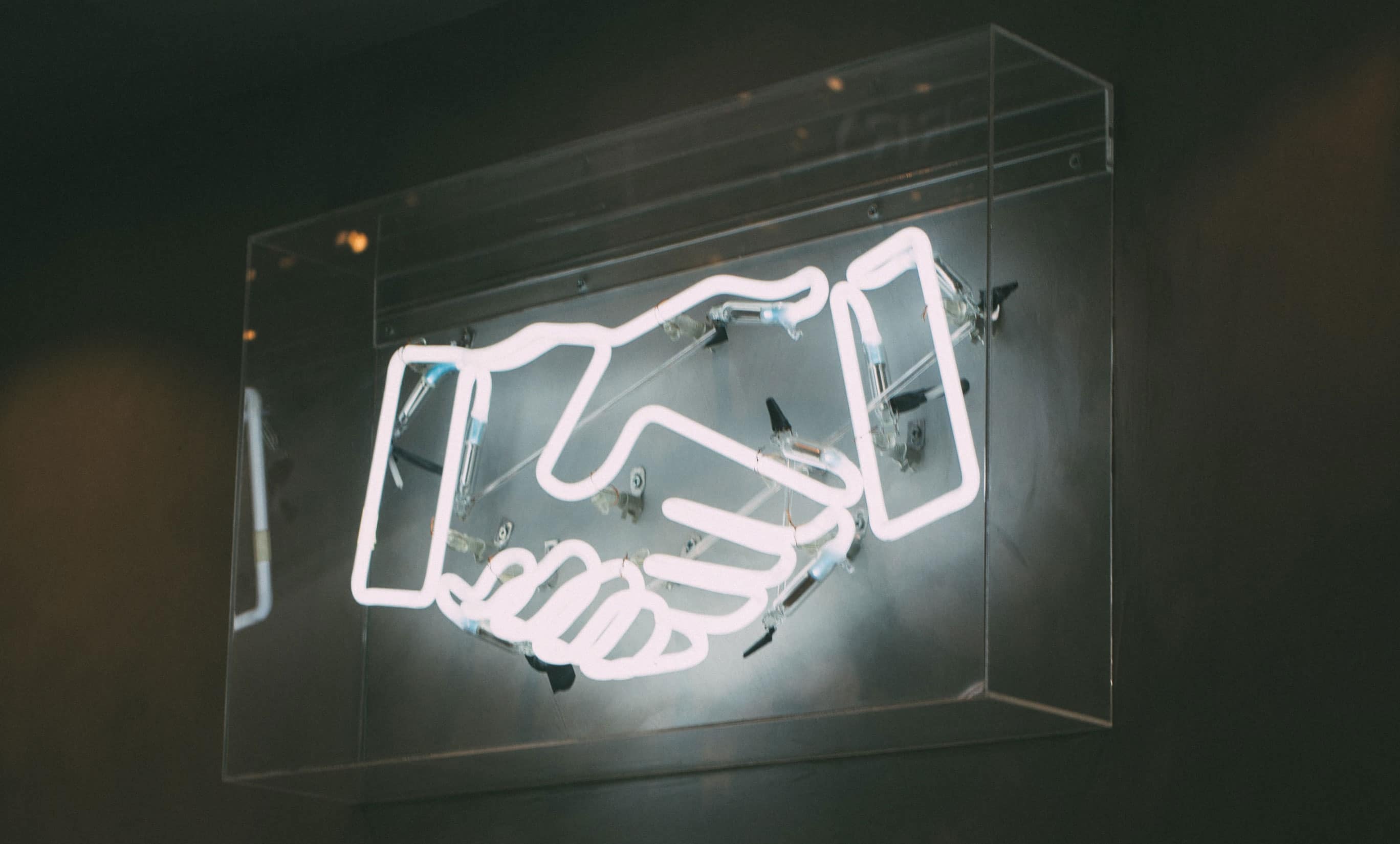 How to Find Good Web Design Clients || Neon sign that is a handshake