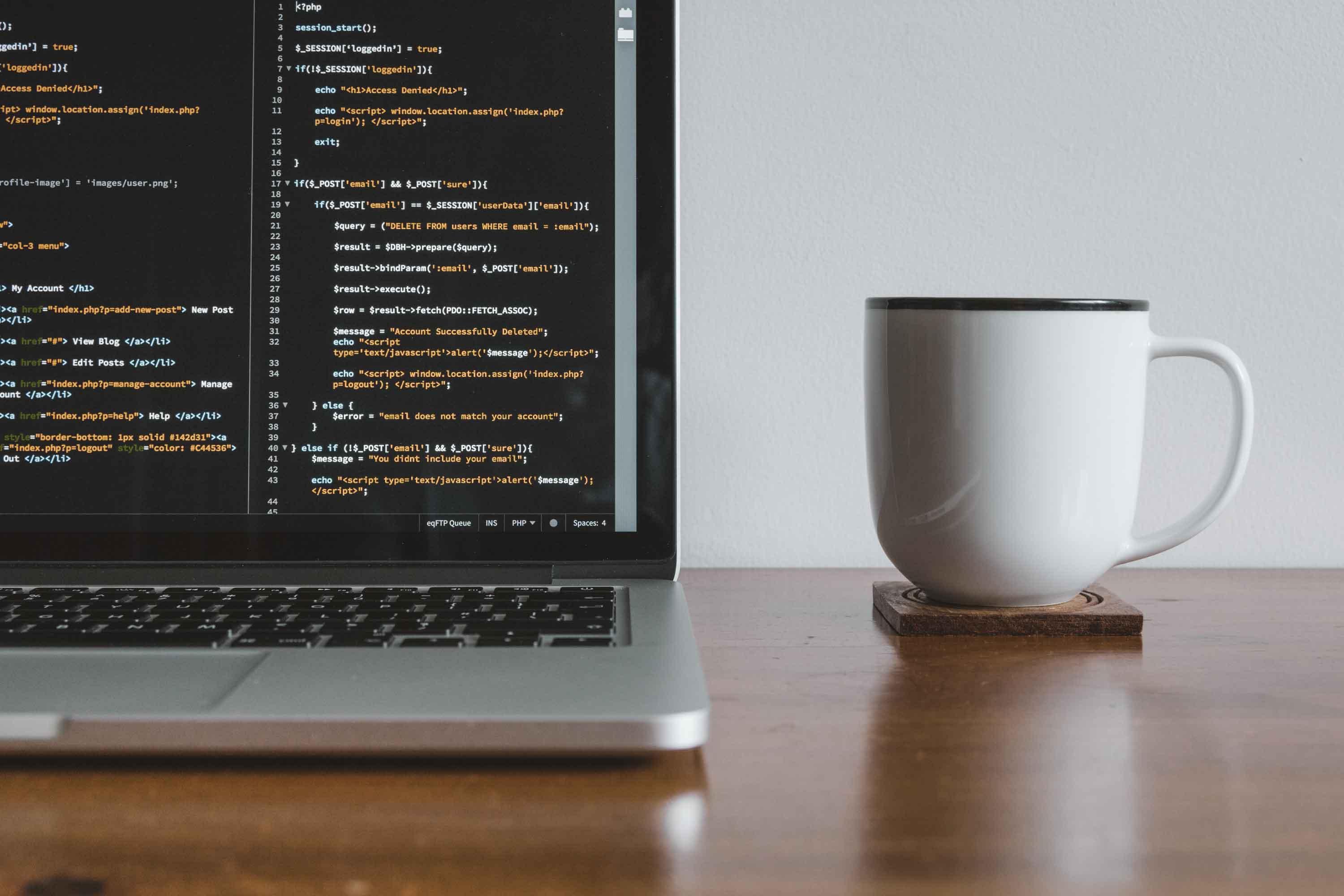 How to Advance Your Career as a Web Developer || A computer with code on it with a cup of coffee