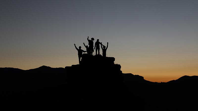 A group of people standing on a rock to symbolize the importance of finding a freelancer community