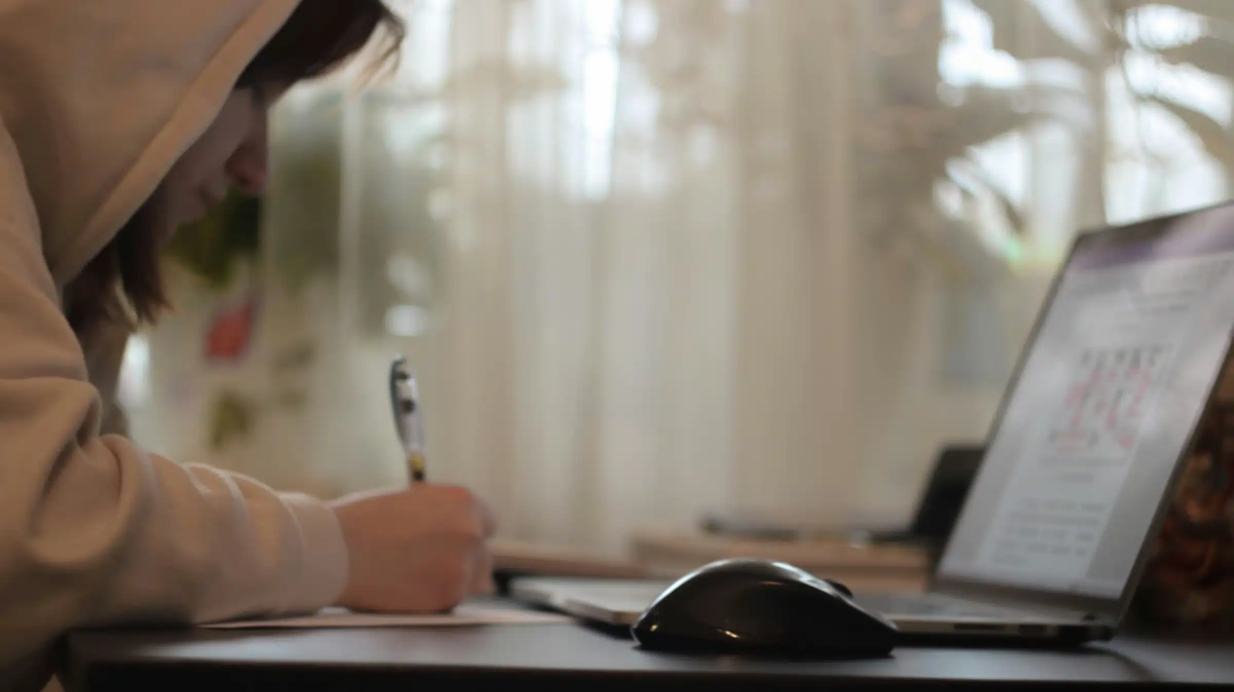 Woman writing in front of computer to illustrate web design client onboarding process